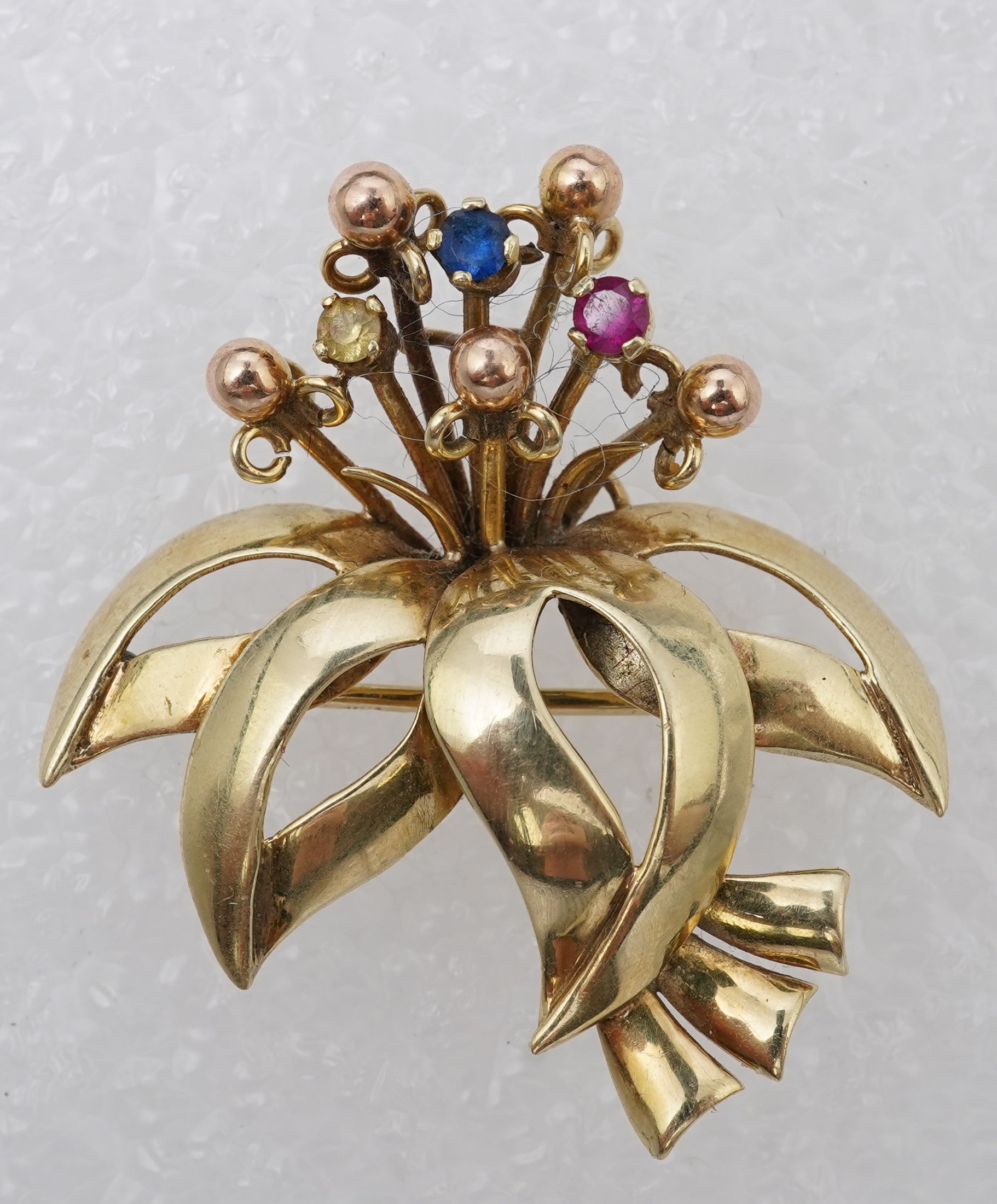 Two brooches and a ring, mid 20th century, comprising: a brooch of floral design, set with circular-cut synthetic gemstones, length 3.7cm, Austrian assay marks for gold, gross weight approximately 6.5 grams; a brooch des